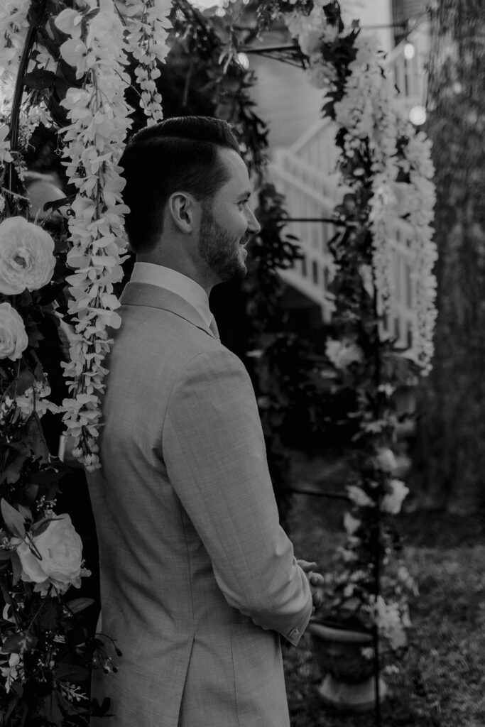 Groom awaiting his bride as she walks down the backyard ceremony aisle