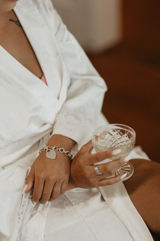 Bride sitting with a glass of champagne