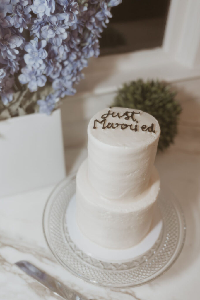 classic white two tier wedding cake that says "just married"