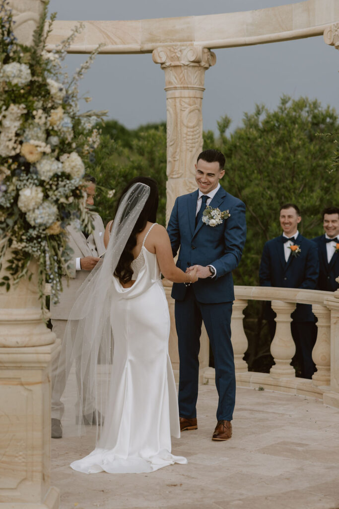 A tuscany-inspired wedding ceremony under a stone gazebo