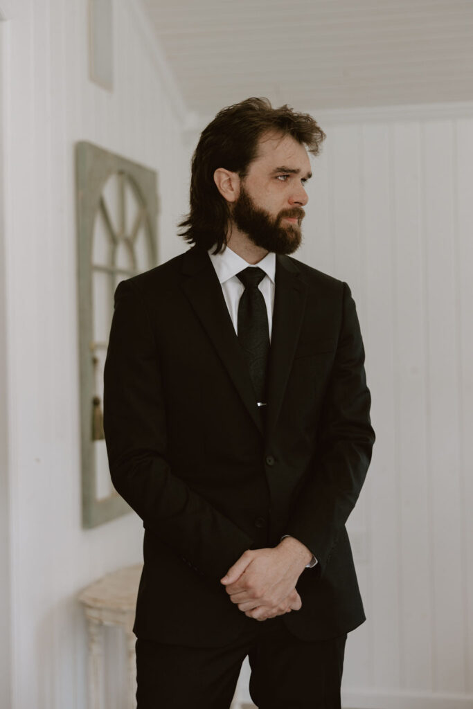 Groom watches his bride walk down the aisle while teary eyed