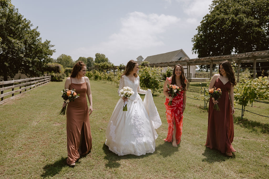 Bride walking with her bridesmaids in mismatched dresses