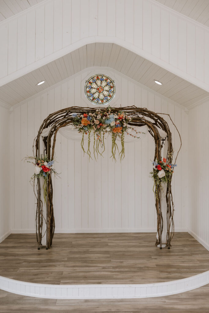 Branch arch with vintage florals at the altar