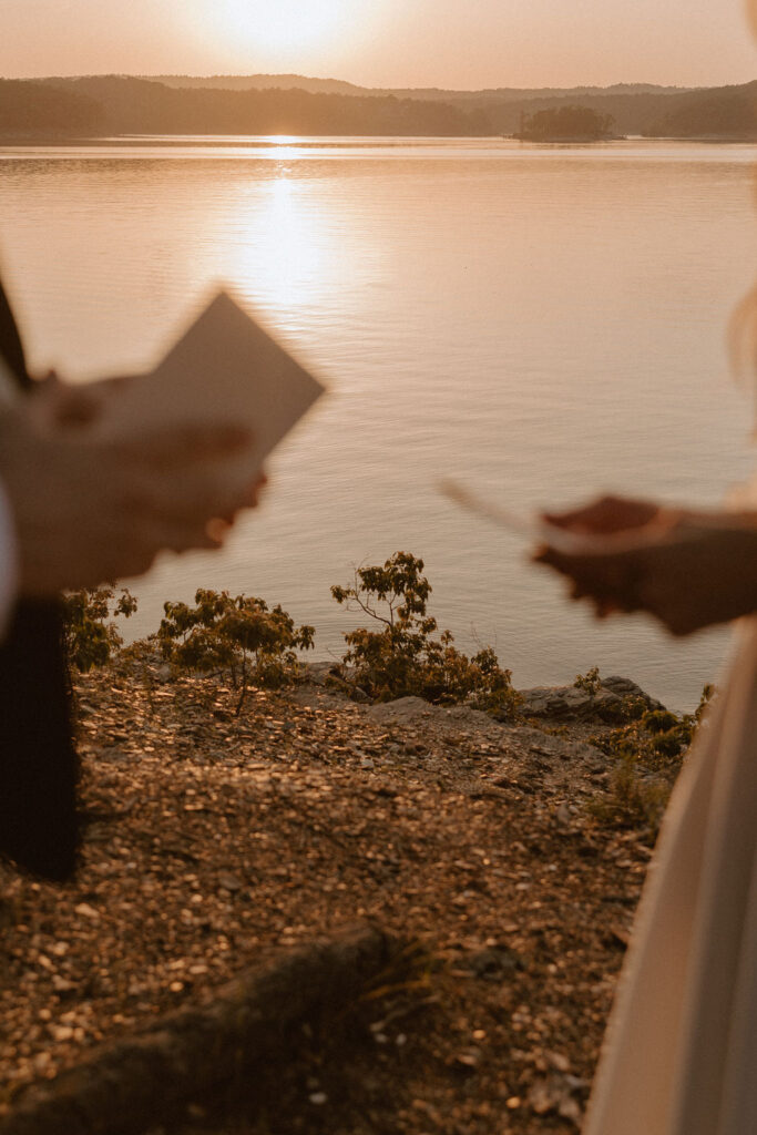 A couple reads their vows by a lake in Oklahoma as the sun sets