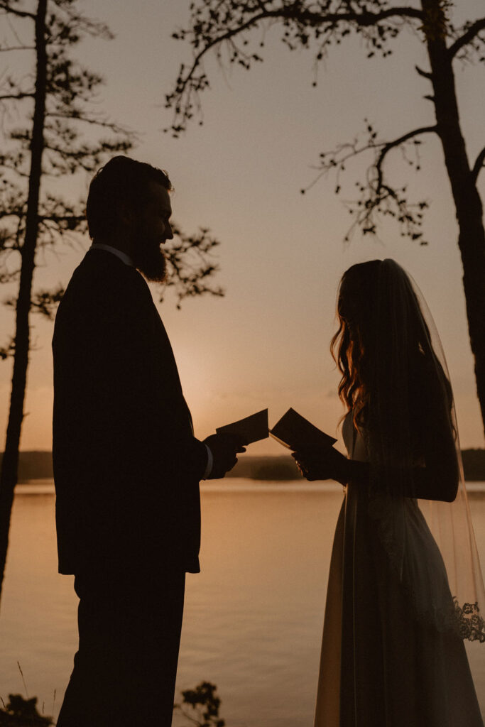 A couple reads their vows by a lake in Oklahoma as the sun sets