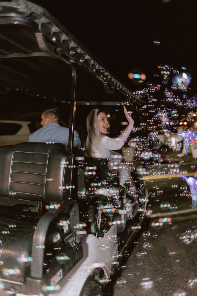 Bride and groom exit on a golf cart from their Eden Gardens state park elopement reception