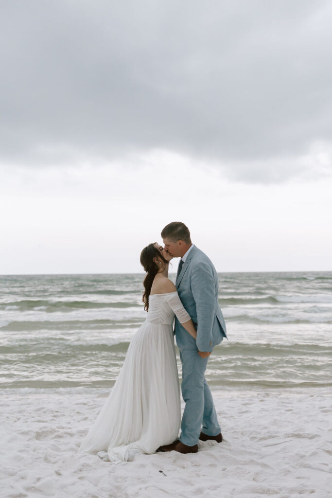 Bride and groom kiss on the white Sandy Shores of Destin, Florida after their Eden Gardens State Park elopement