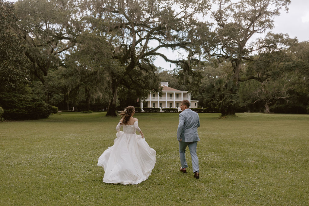 Bride and groom run through the lawn of their Destin, Florida elopement ceremony location