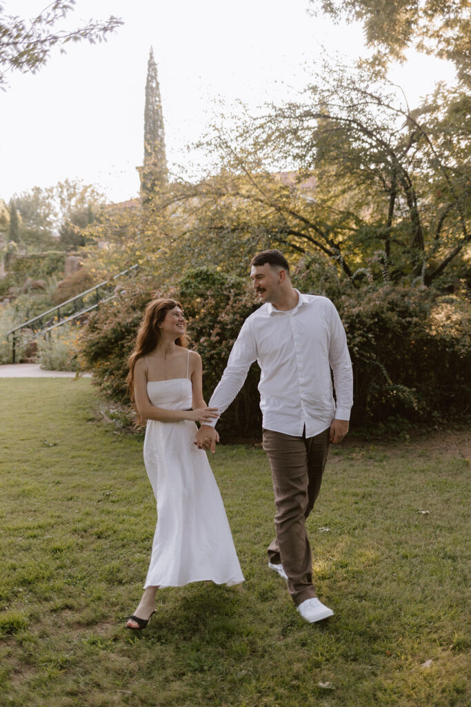 A couple walk-through the lawn of Philbrook Museum of art during their engagement session