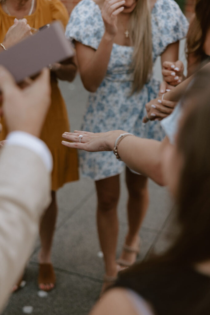 Woman shows off her new engagement ring to her family