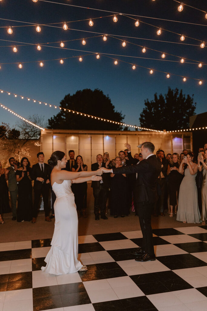 A lively wedding reception dance party on a checkered dance floor