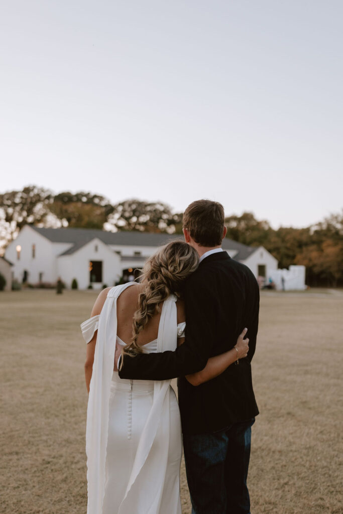 Bride and groom stand together looking at Sorelle - The Meadow on Deer Creek