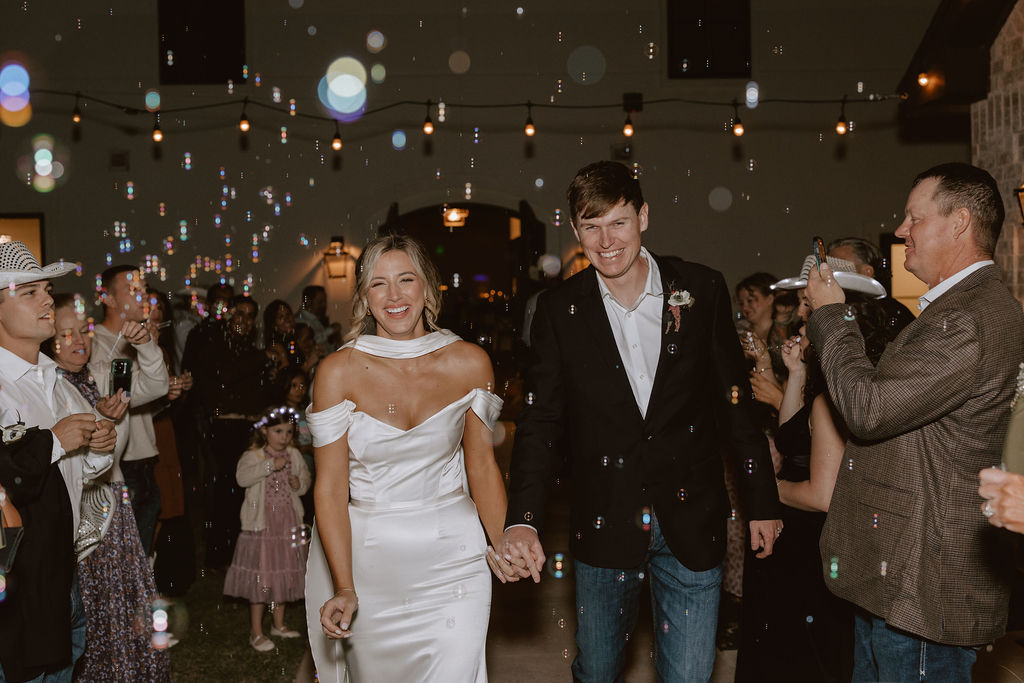 Bride and groom leave their Sorelle wedding reception with a bubble send-off