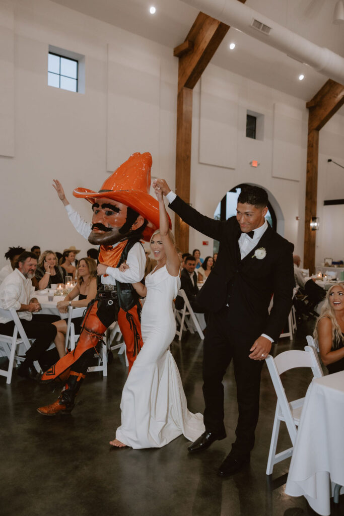 Bride and groom walk into the reception with Pistol Pete