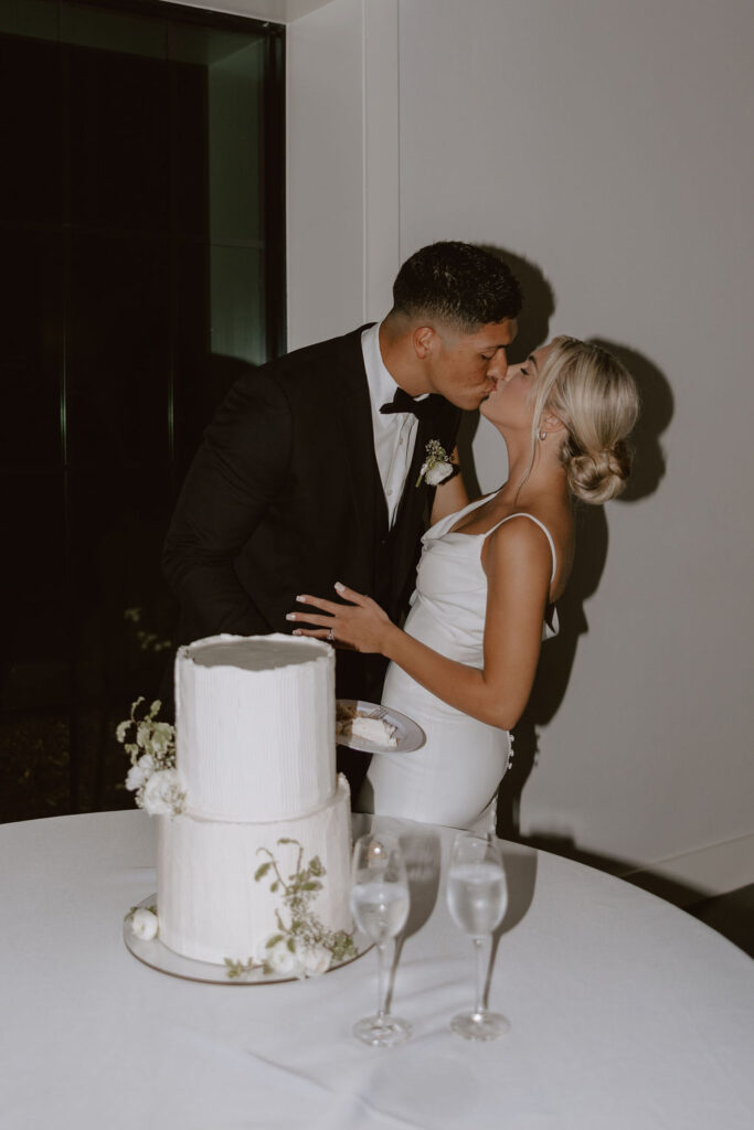 Bride and groom cut into a classic two-tiered white cake