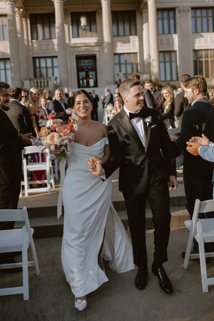 Documentary wedding photography of bride and groom walking down the aisle together