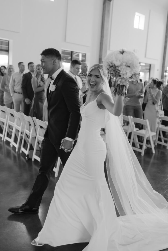 Documentary photography of bride and groom walking back down the aisle together
