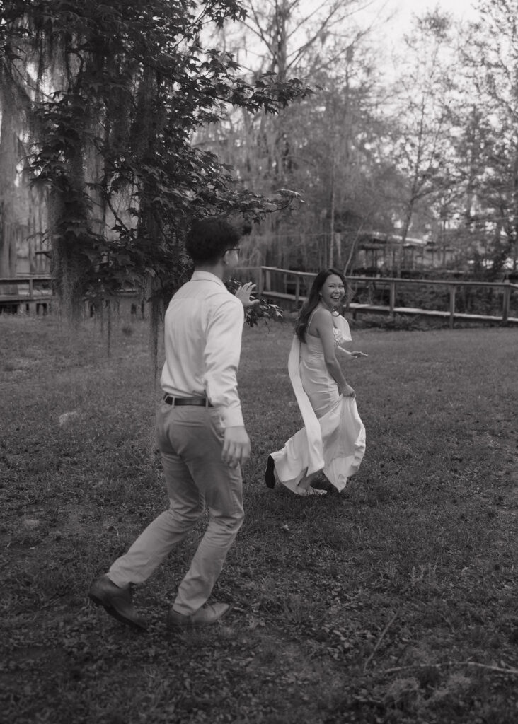 Couple playfully runs around in the grass