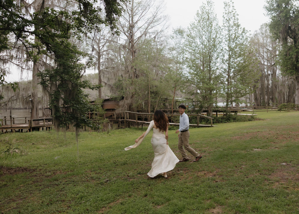 Couple playfully runs around in the grass