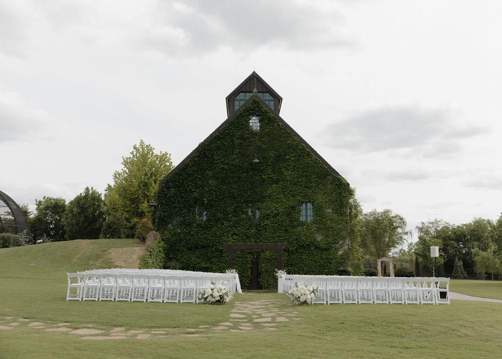 ceremony setup outside of the ivy colored stone barn at The Baumberhof wedding venue