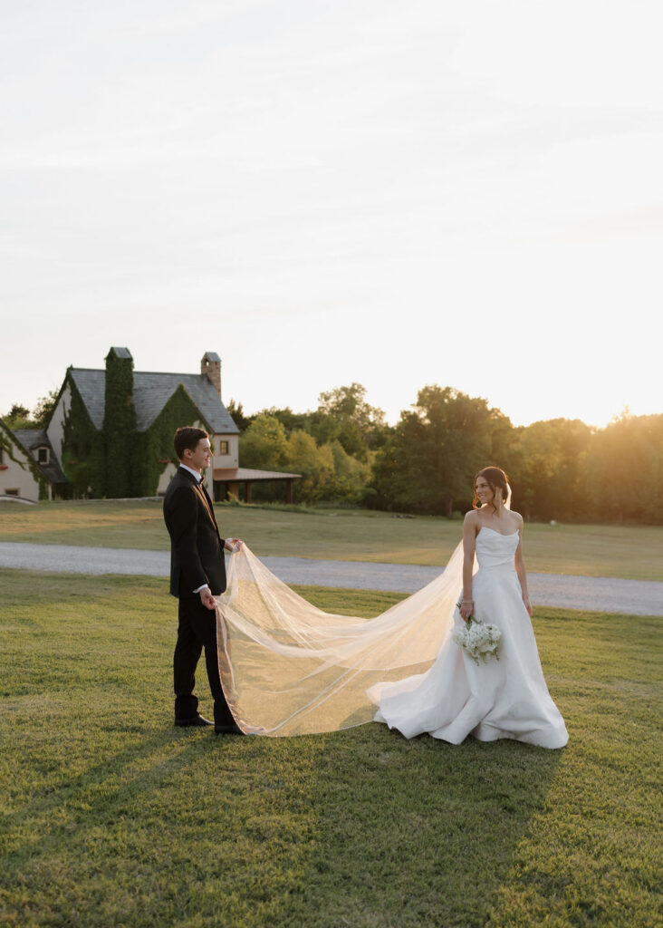 Bride and groom walk on the lawn at The Baumberhof wedding venue at sunset
